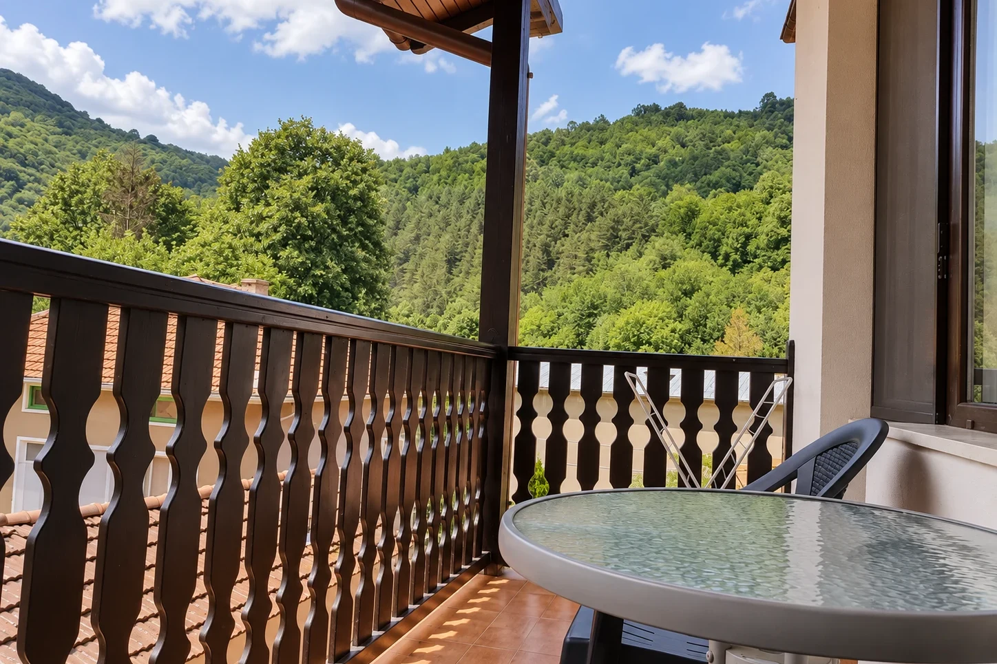 The Family Room balcony with a table and a view of the hills